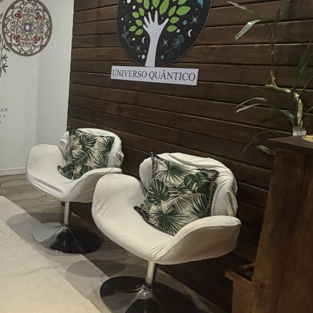 As poltronas brancas com almofadas de folhagem onde acontecem as conversas.
